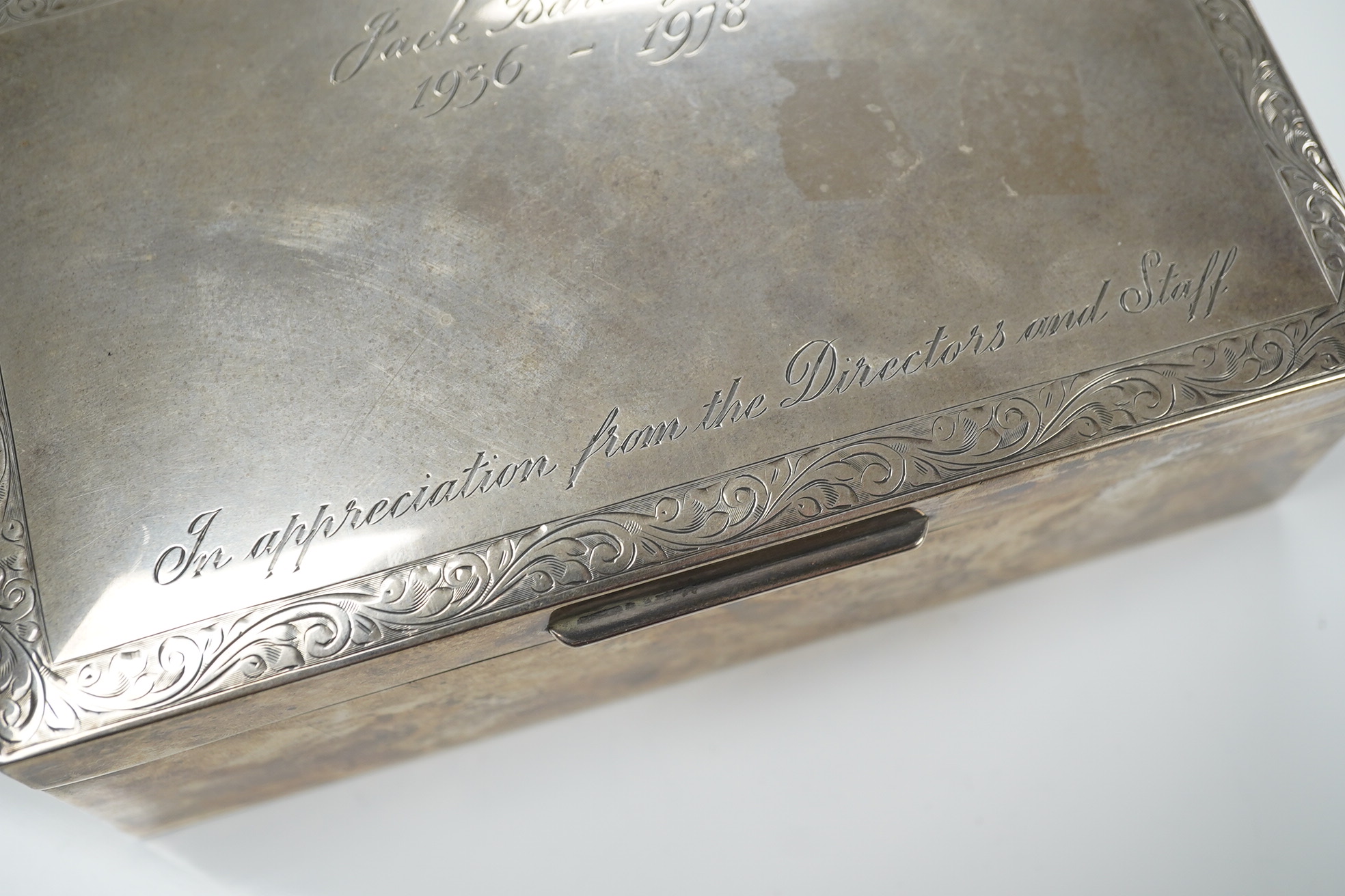 An Elizabeth II silver mounted rectangular cigarette box, with engraved inscription, C.S. Green & Co, Birmingham, 1975, 16.4cm. Condition - poor to fair